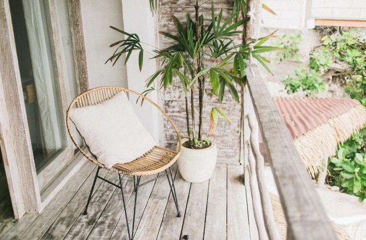 Na zdjęciu widzimy balkon na którym stoi krzesło oraz donica z rośliną.